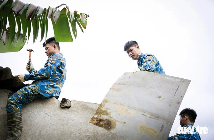 Chiến sĩ Sư đoàn không quân 372 sửa chữa mái tôn nhà dân bị hư hại sau vụ rơi máy bay Su-22 tại thị xã Điện Bàn, tỉnh Quảng Nam - Ảnh: C.S.