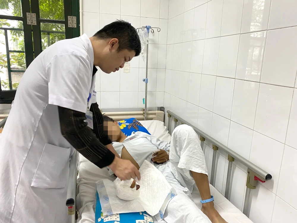 Bác sỹ khám và điều trị cho bệnh nhân bị tai nạn do pháo nổ. (Ảnh: PV/Vietnam+)