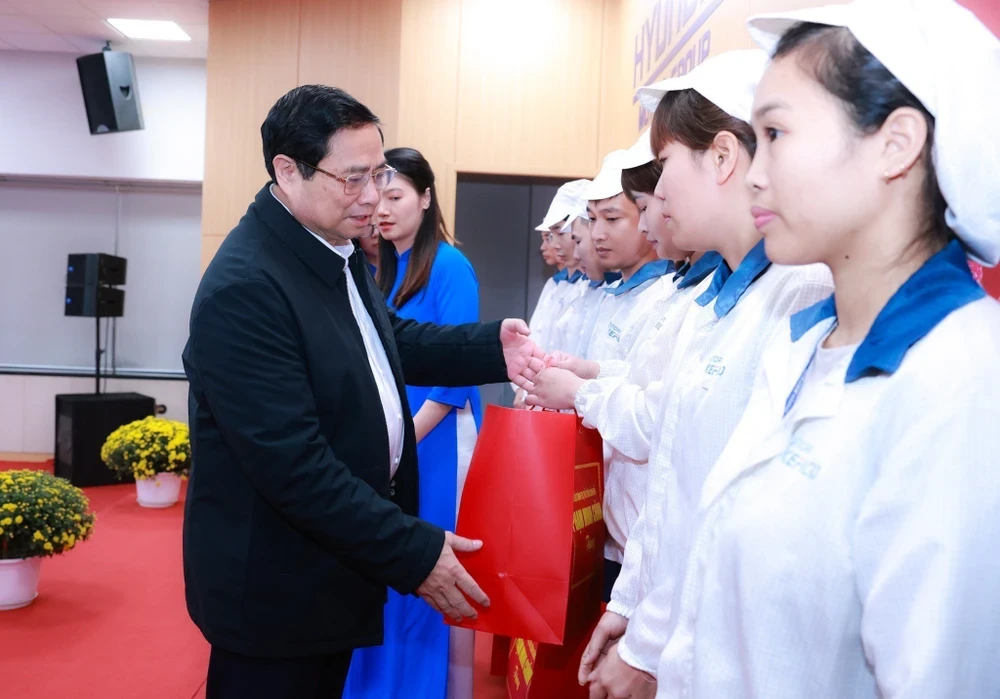 Thủ tướng Phạm Minh Chính tặng quà cho công nhân, người lao động có hoàn cảnh khó khăn. (Ảnh: Dương Giang/TTXVN)