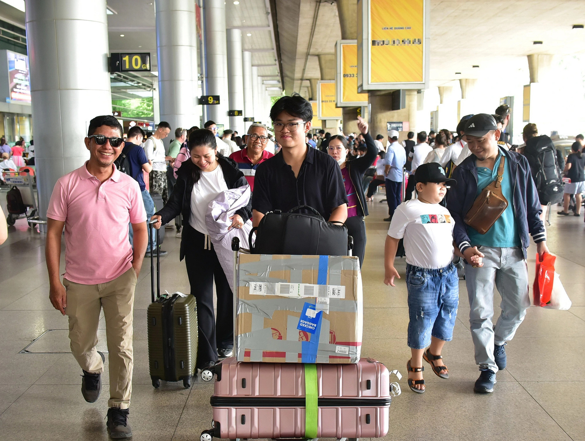 Anh Thanh Tùng (trái) đón thân nhân từ Mỹ về Việt Nam ăn Tết. Ảnh chụp tại sân bay Tân Sơn Nhất (TP.HCM) vào chiều 20-1 - Ảnh: T.T.D.