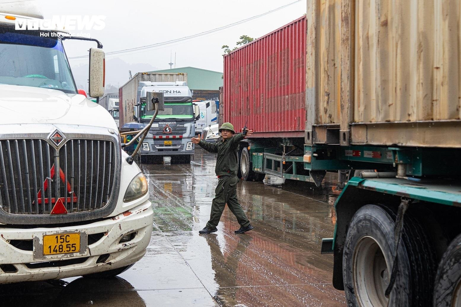 Nhân viên an ninh tại bãi xe Xuân Cương (cửa khẩu quốc tế Hữu Nghị) đội mưa điều phối các xe hàng di chuyển, tránh ùn tắc.