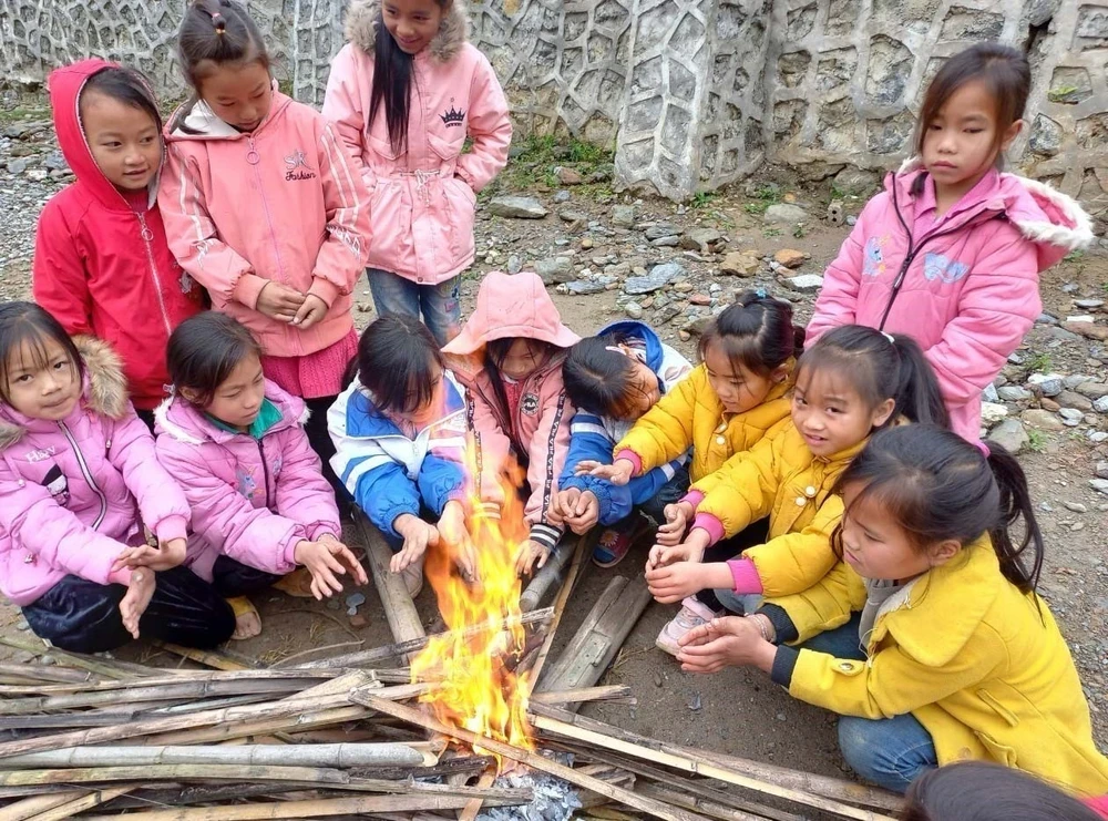 Học sinh huyện Nguyên Bình, Cao Bằng đốt lửa sưởi trong giờ nghỉ giải lao. (Ảnh: TTXVN phát)