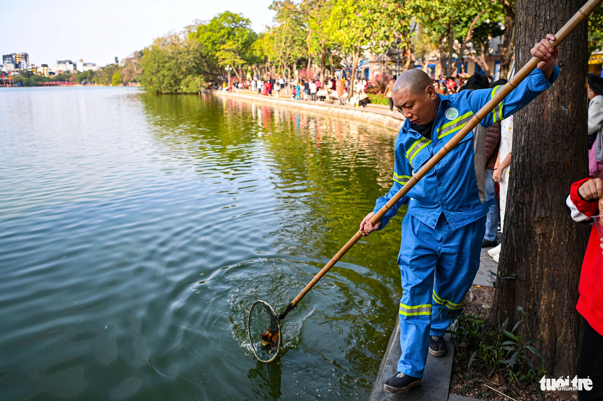 Các công nhân môi trường liên tục dọn rác và vớt lá cây rơi xuống hồ để đảm bảo cảnh quan luôn sạch, đẹp - Ảnh: HỒNG QUANG
