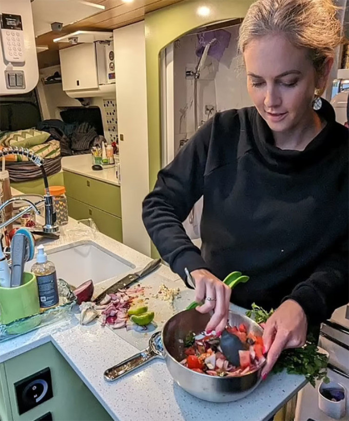 Caitlin nấu ăn trong nhà bếp trên ôtô. Cô ăn uống theo chế độ lành mạnh, nhiều rau củ quả. Ảnh: SWSN