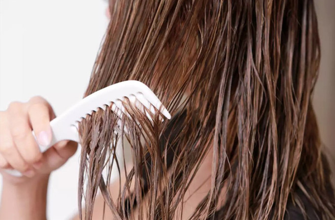 Thói quen chải tóc khi đang ướt là nguyên nhân gây rụng nhiều. Ảnh: Xinhua