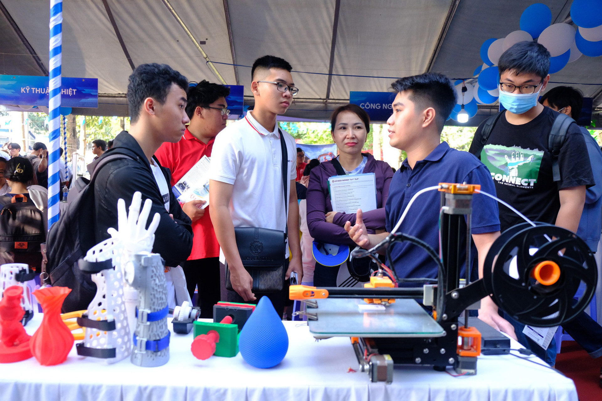 Học sinh cùng phụ huynh tham khảo tại bàn trưng bày máy in 3D của Trường đại học Bách khoa, Đại học Quốc gia TP.HCM - Ảnh: NGỌC PHƯỢNG