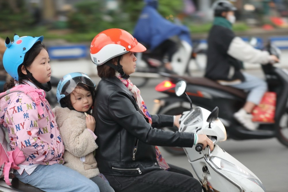 Người dân Thủ đô trang bị áo chống rét khi tham gia giao thông. (Ảnh: Thanh Tùng/TTXVN)