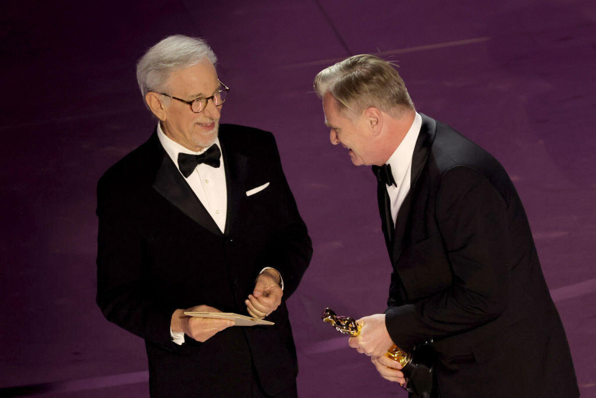 Christopher Nolan (phải) trên bục nhận giải Đạo diễn xuất sắc nhất. Ông ôm chầm lấy người bạn, người đàn anh lớn trong ngành điện ảnh Steven Spielberg trong phút giây xúc động của mình - Ảnh: GETTY IMAGES