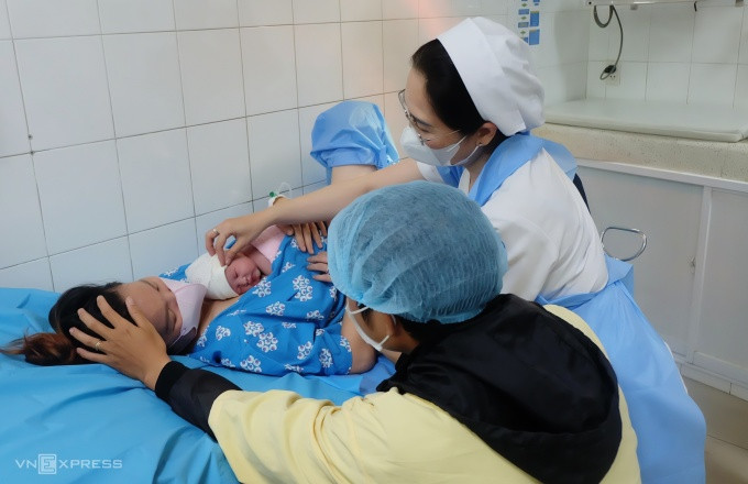 Bé Trương Nhã An, một trong 5 công dân tuổi Rồng đầu tiên, cùng ba mẹ tại Bệnh viện Từ Dũ, TP HCM. Ảnh: Thi Quân.