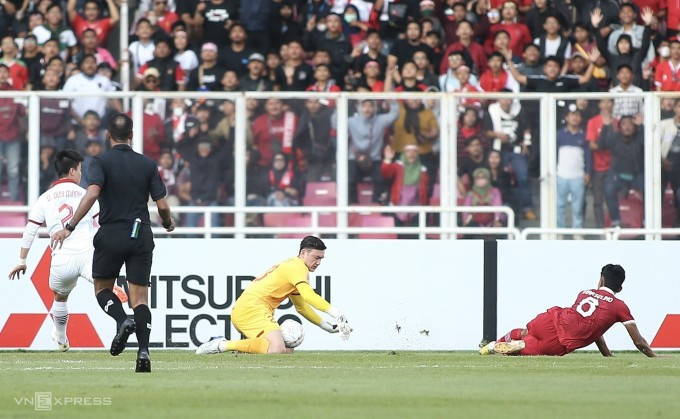 Đặng Văn Lâm (áo vàng) cản phá cú sút của Marselino Ferdinan (áo đỏ) trong trận Việt Nam hòa Indonesia 0-0 ở bán kết lượt đi AFF Cup 2022. Ảnh: Lâm Thoả