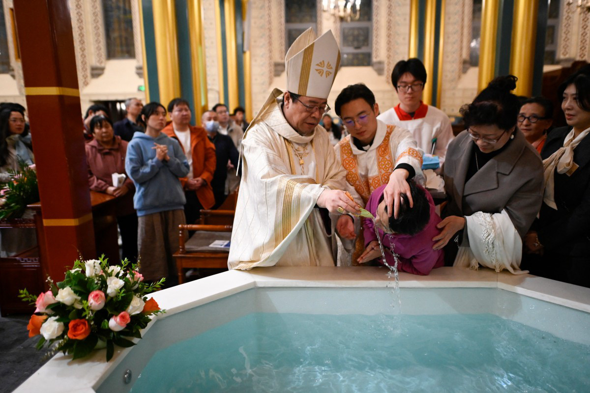 Một tín hữu được rửa tội trong đêm Vọng Phục sinh (tức đêm trước ngày Phục sinh) tại một nhà thờ ở thủ đô Bắc Kinh, Trung Quốc vào tối 30-3 - Ảnh: AFP