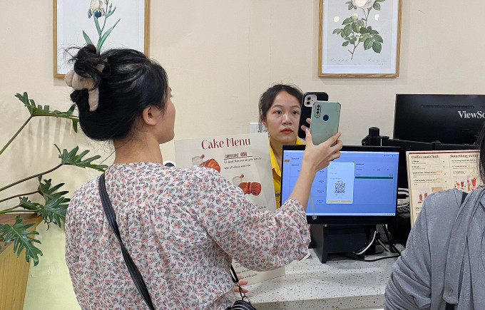Một khách hàng quét mã QR code tại một quán cà phê tại quận Thanh Xuân, Hà Nội được nhân viên chụp lại biên lai giao dịch, tháng 4/2024. Ảnh: Quỳnh Nguyễn