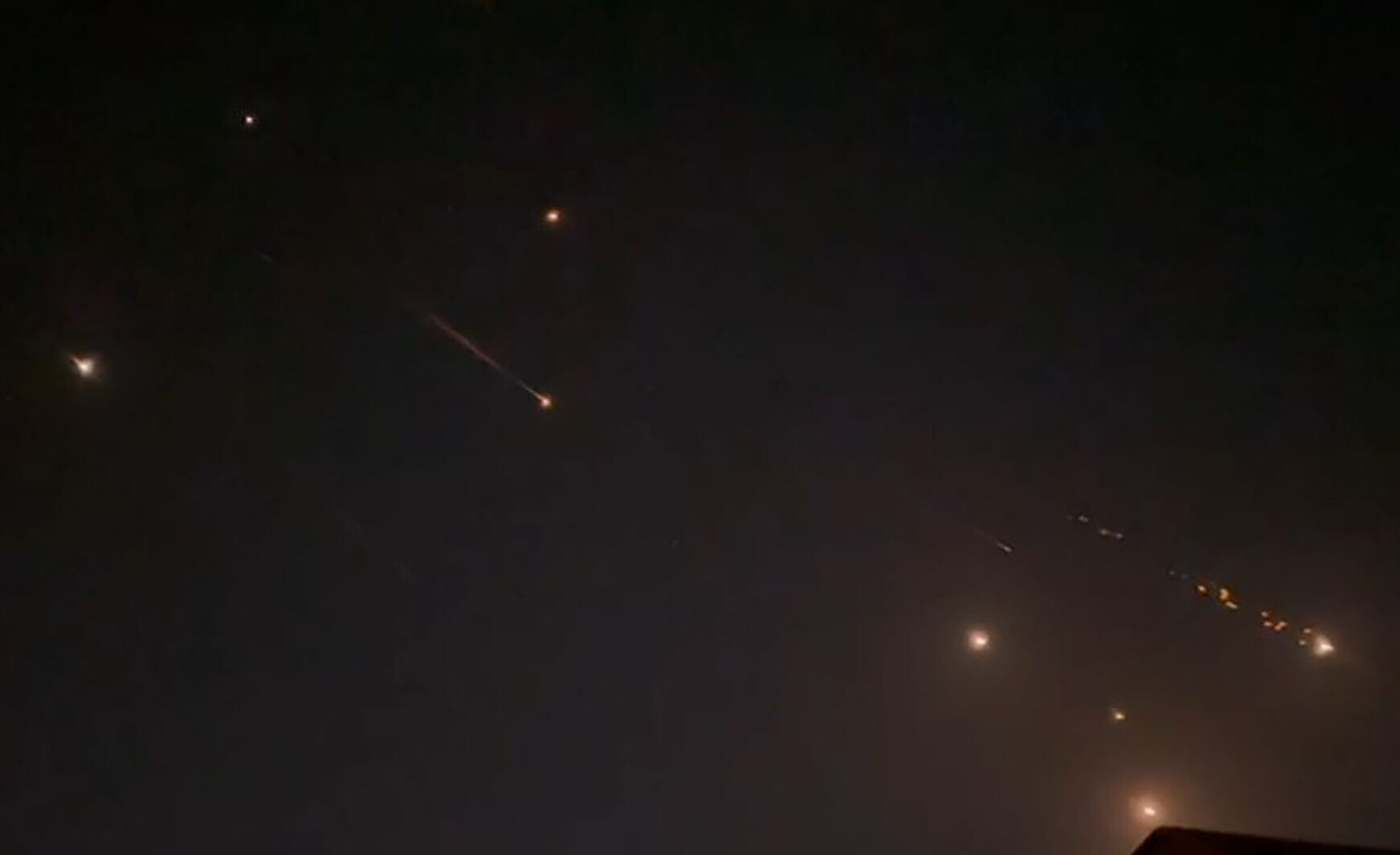 Bầu trời tại thành phố Hebron ở Bờ Tây sáng rực ngày 14-4 trong khi Iran không kích Israel - Ảnh: AFP