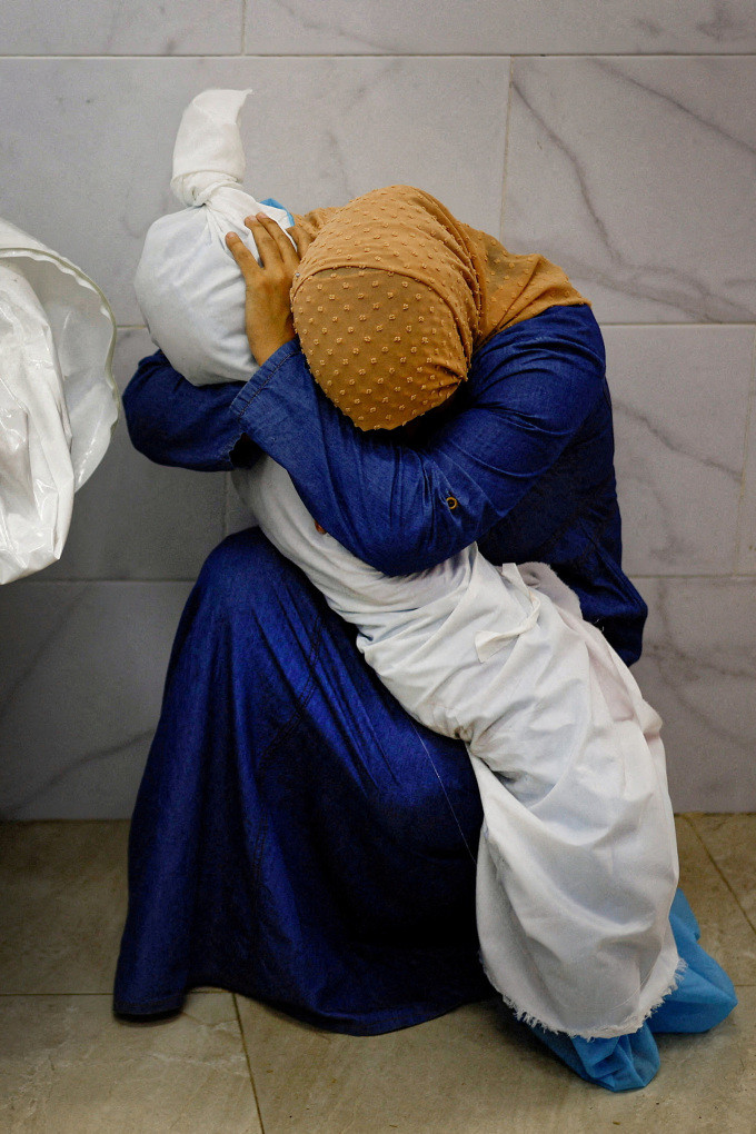 Inas Abu Maamar ôm thi thể cháu gái trong bệnh viện ở thành phố Khan Younis, nam Gaza ngày 17/10/2023. Ảnh: Reuters