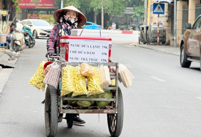 Một phụ nữ ngoại tỉnh đến bán hàng tại một vỉa hè trên phố Thái Thành, Hà Nội. Ảnh: Phạm Nga