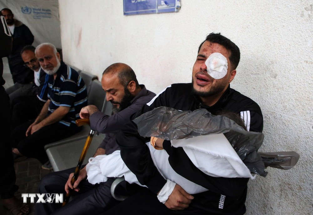 Người đàn ông bị thương ôm thi thể một nạn nhân sau vụ không kích của Israel xuống thành phố Rafah, miền Nam Gaza ngày 4/4/2024. (Ảnh: THX/TTXVN)