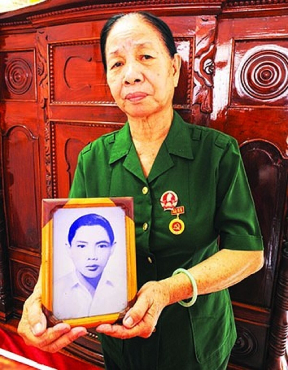 Cô Năm Lan với tấm hình anh Út Nhị tại nhà riêng. Ảnh chụp tháng 4/2023. Ảnh: Trần Nguyễn Anh