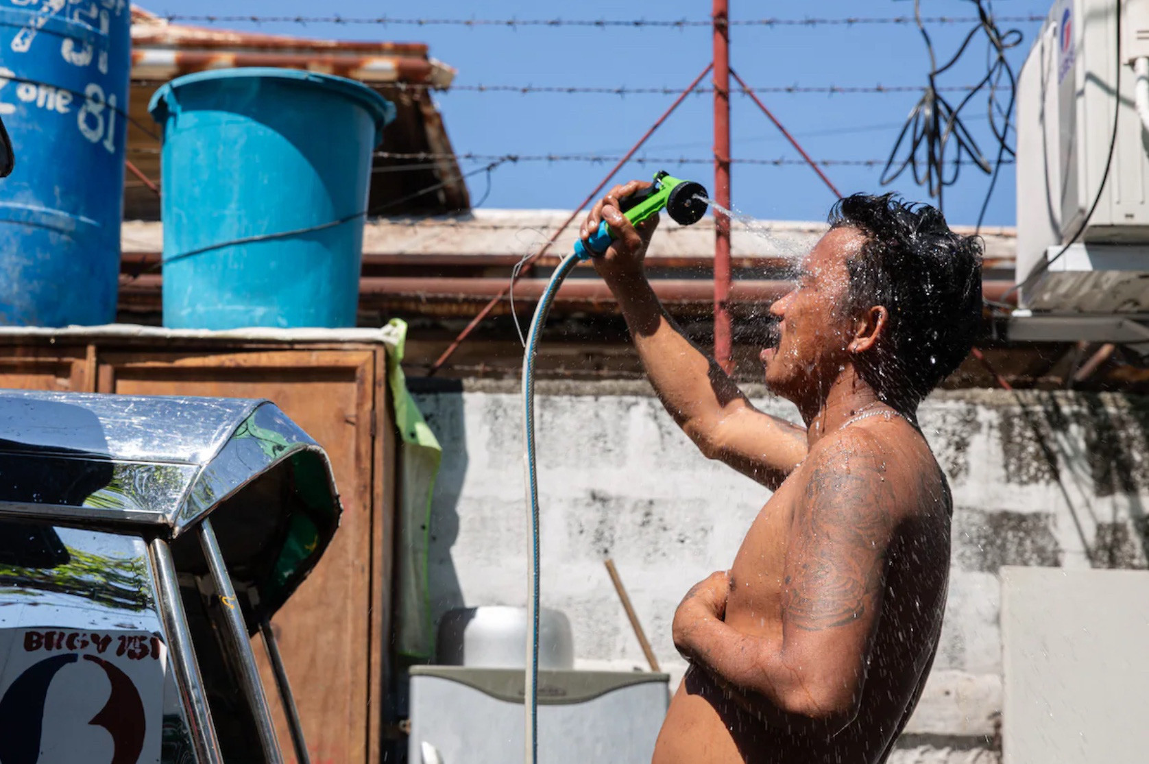 Một người đàn ông tắm trong thời tiết nắng nóng ở thủ đô Manila, Philippines ngày 30-4 - Ảnh: AFP