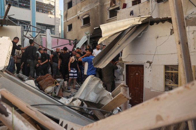 Người dân đứng cạnh ngôi nhà bị sập do cuộc không kích của Israel vào thành phố Rafah, nam Gaza ngày 5/5. Ảnh: AFP