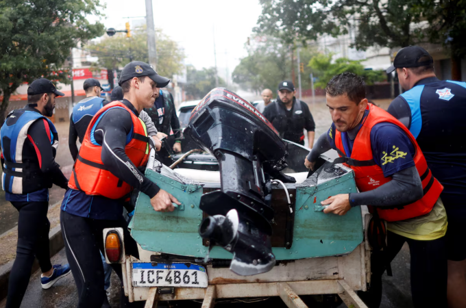 VĐV rowing Evaldo Becker (phải) và Piedro Tuchtenhagen (trái) tham gia cứu trợ trong trận lũ lịch sử ở bang Rio Grande do Sul. Ảnh: Reuters