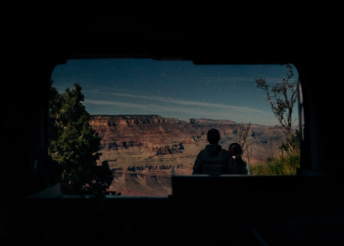 Cặp vợ chồng qua cửa chiếc xe tự lái ngắm sao đêm tại hẻm núi Grand Canyon trong chuyến lái xe đi xuyên 23 công viên quốc gia Mỹ. Họ có 10 ngày dự kiến đi 3.000 km, nên hai vợ chồng đã thay phiên nhau lái. Ảnh: Nhân vật cung cấp