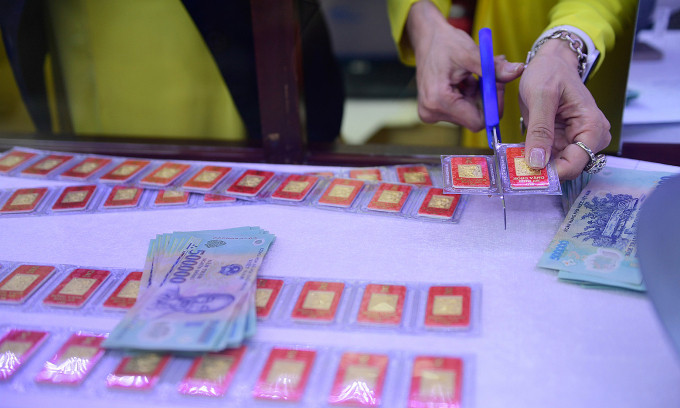 Nhân viên lấy vàng miếng cho khách tại cửa hàng SJC trên đường Nguyễn Thị Minh Khai, quận 3, ngày 19/2. Ảnh: Thanh Tùng
