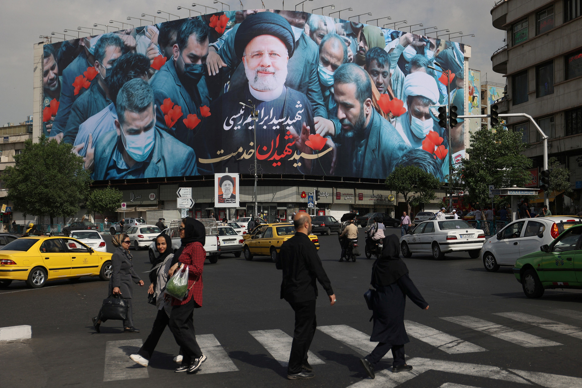 Người dân đi ngang tấm biển có hình cố Tổng thống Ebrahim Raisi trên đường phố thủ đô Tehran ngày 21-5 - Ảnh: REUTERS