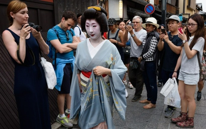 Du khách vây quanh geisha ở Kyoto. Ảnh: Akio Kon