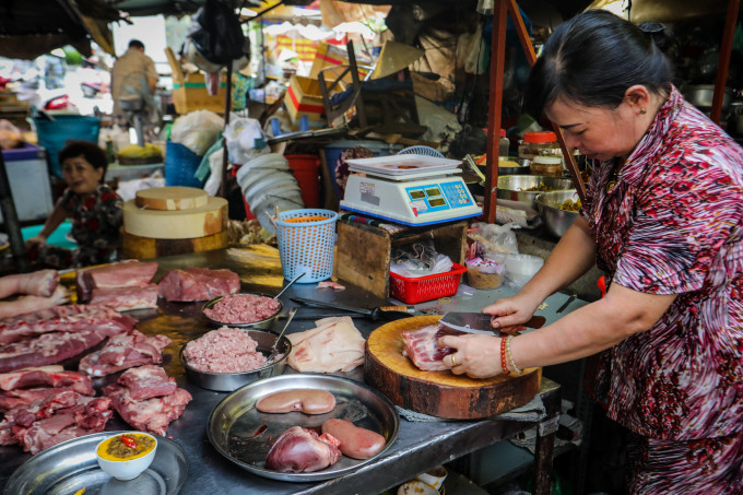 Tiểu thương bán thịt heo tại chợ chung cư Vĩnh Hội (quận 4, TP HCM). Ảnh: Hoàng Phong