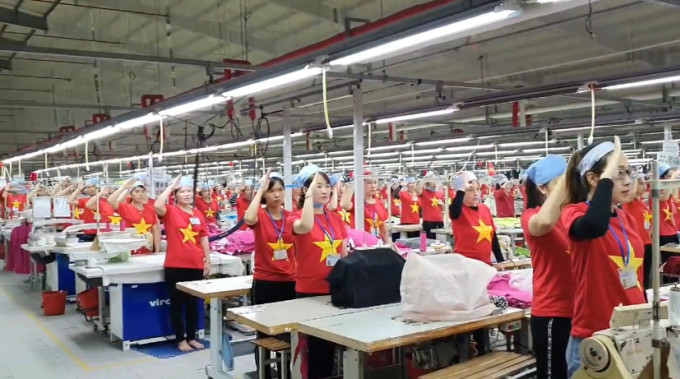 Các nữ công nhân ở huyện Diễn Châu, Nghệ An mặc áo cờ đỏ sao vàng tham gia lễ chào cờ vào mỗi sáng thứ hai. Ảnh chụp màn hình