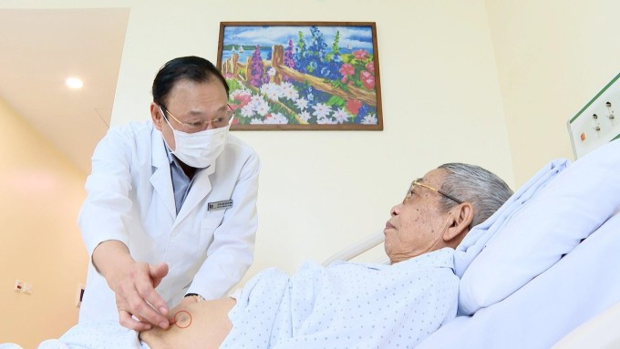 Phó giáo sư Triều Dương kiểm tra vết mổ nội soi rất nhỏ (khoanh đỏ) cho người bệnh. Ảnh: Bệnh viện Đa khoa Tâm Anh