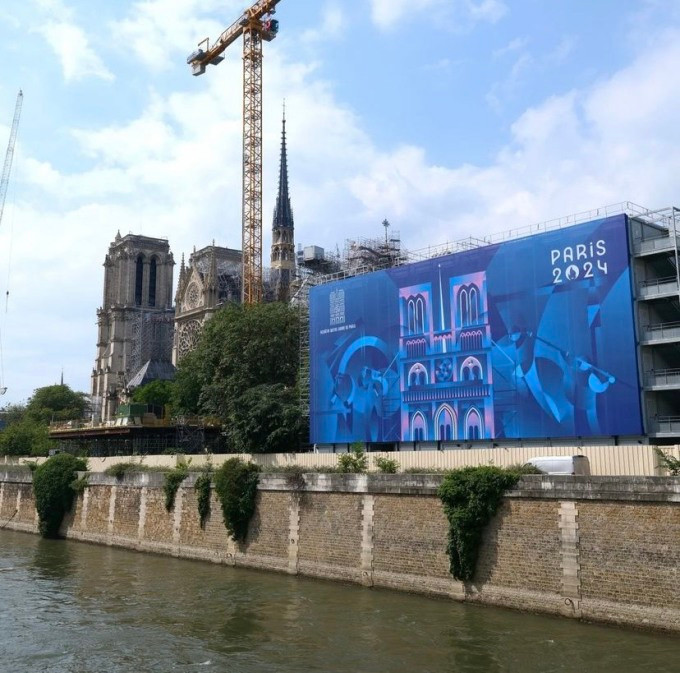 Một phần tường Nhà thờ Đức Bà Paris hôm 21/6 khoác lên mình tấm áp phích mới chào mừng Thế vận hội Olympic, Paralympic và lễ tái khai trương nhà thờ vào tháng 12. Ảnh: Notre-Dame de Paris.