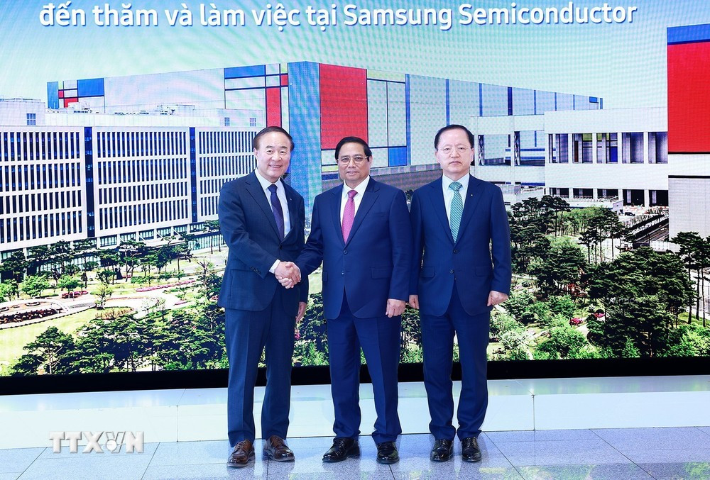 Giám đốc điều hành, Phó Chủ tịch Tập đoàn Samsung Young Hyun Jun và ông Park Hark Kyu, Tổng Giám đốc phụ trách tài chính của tập đoàn Samsung đón Thủ tướng Phạm Minh Chính. (Ảnh: Dương Giang/TTXVN)