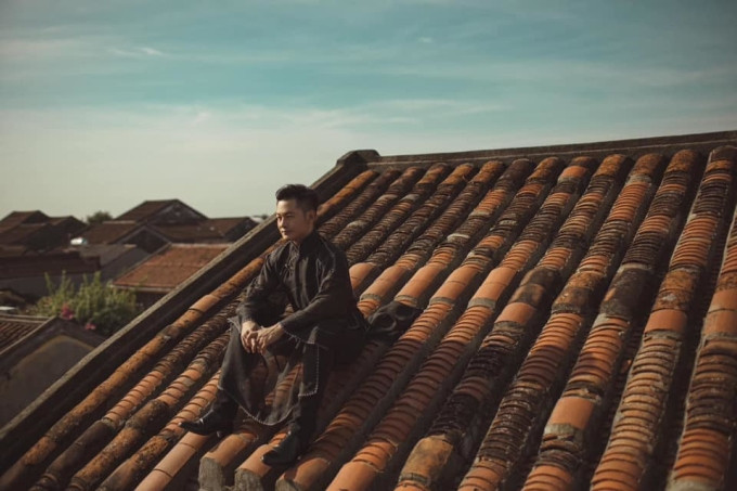 Ca sĩ Đức Tuấn ngồi trên mái nhà ở phố cổ Hội An. Ảnh: Facebook Đức Tuấn - The Divo