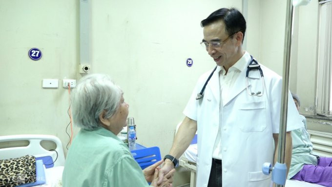GS Tuấn khám, trò chuyện với cụ bà 86 tuổi - người ông đặt stent cho 20 năm trước. Ảnh: Huy Mạnh