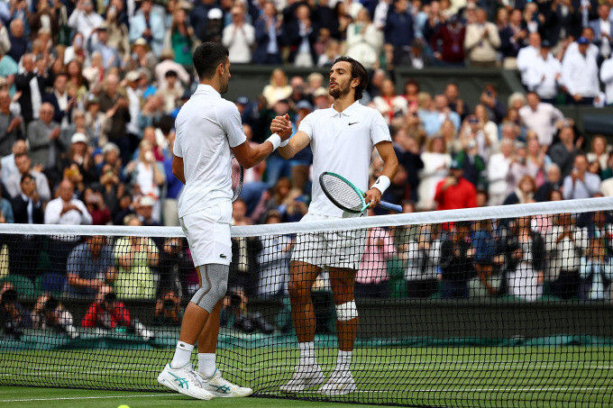 Djokovic (trái) bắt tay Musetti sau trận bán kết trên sân Trung tâm Wimbledon, hôm 12/7. Ảnh: Reuters