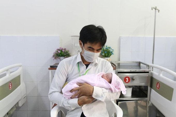 Tuấn Anh, con trai chị Thơm bế em sau khi mẹ sinh, tháng 12/2021. Ảnh: Nhân vật cung cấp