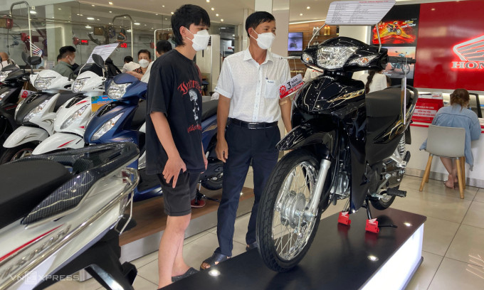Người dân tham khảo xe máy Honda tại một Head ở quận Bình Thạnh. Ảnh:Phạm Trung