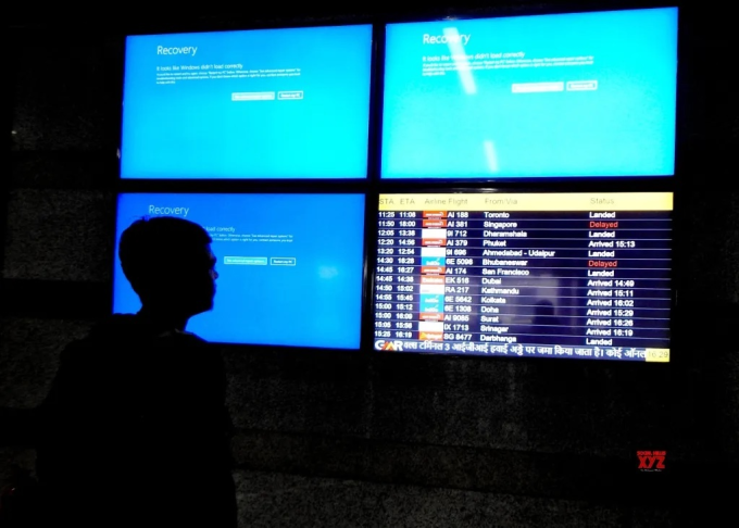 Hành khách đứng trước màn hình xanh chết chóc tại sân bay ở New Delhi (Ấn Độ) ngày 19/7. ẢnhIANS/Anupam Gautam