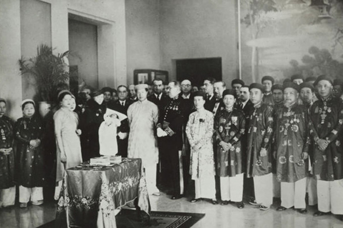 Hoàng hậu Nam Phương (thứ ba từ trái qua) và vua Bảo Đại (thứ năm từ trái qua) trong buổi giới thiệu thái tử Bảo Long, tháng 2/1936, đăng trong sách Hoàng gia và Chức sắc Đông Dương (xuất bản năm 1943).