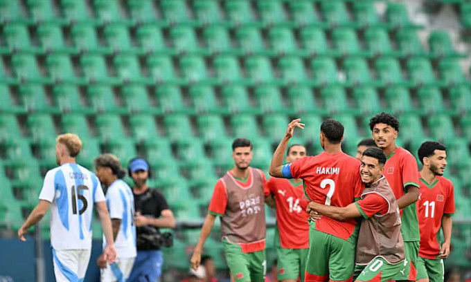 Cầu thủ Morocco mừng chiến thắng sau hiệu còi mãn cuộc lần hai, khi khán đài không còn khán giả. Ảnh: AFP