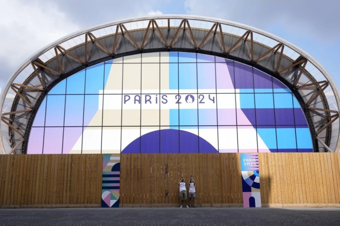Hai du khách chụp ảnh trước một địa điểm thi đấu của Thế vân hội Paris 2024 ngày 24/7. Ảnh: AP