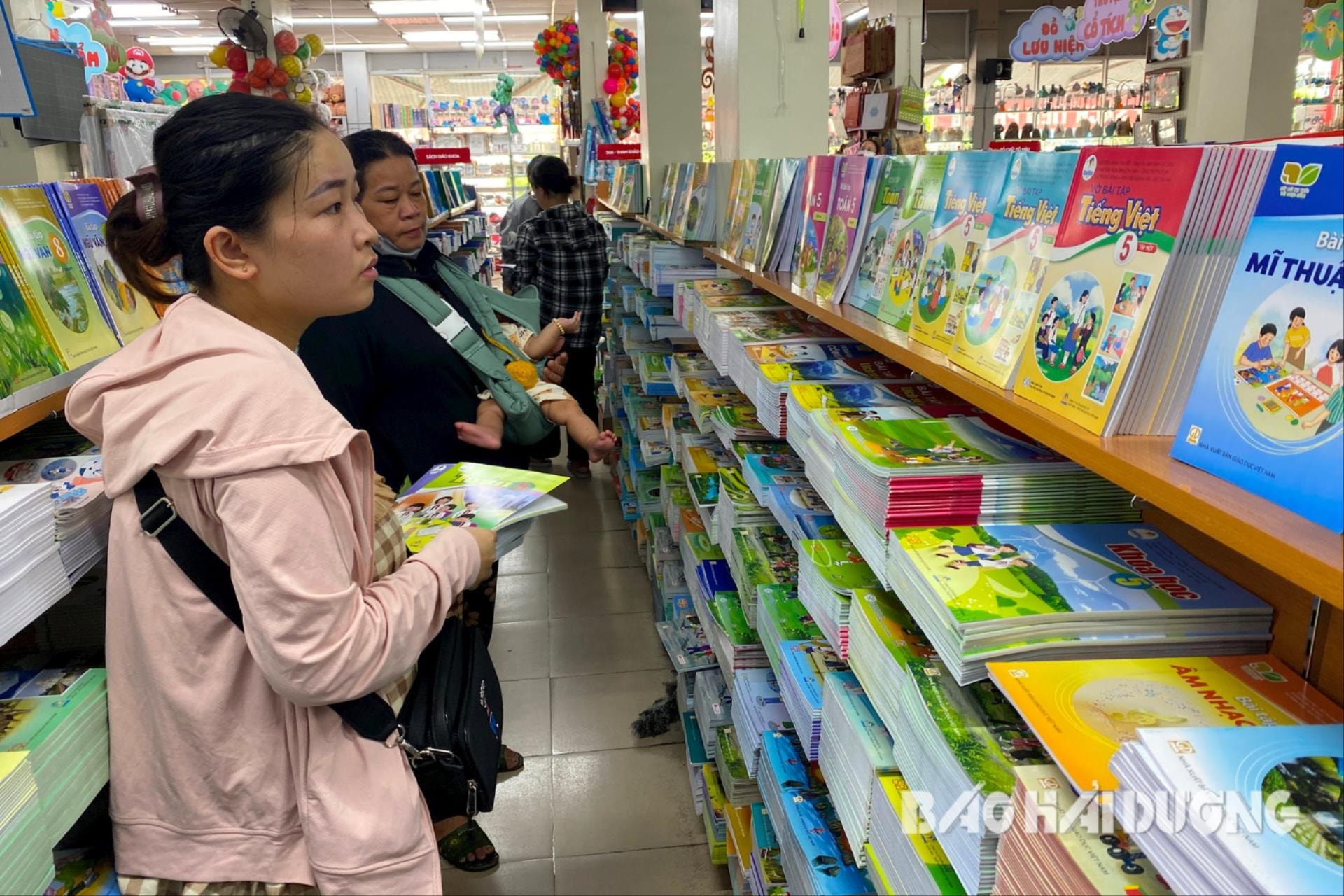 Phụ huynh chọn mua sách cho con tại một hiệu sách ở TP Hải Dương