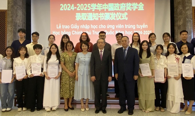 Đại sứ Trung Quốc Hùng Ba và bà Nguyễn Thị Thanh Minh, Phó cục trưởng Hợp tác Quốc tế, Bộ Giáo dục và Đào tạo, chụp ảnh cùng các học sinh trúng tuyển học bổng CSC năm nay. Ảnh: Bình Minh