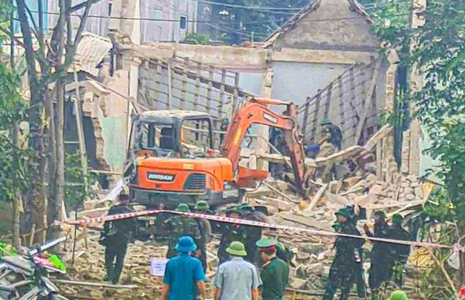 Lực lượng chức năng đang rà vật liệu nổ tại hiện trường, sáng 30/8. Ảnh: Hùng Lê