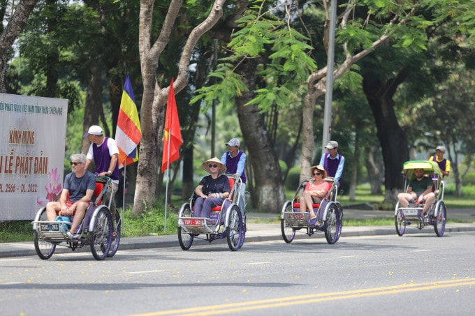 Du khách nước ngoài tham quan thành phố Huế bằng xe xích lô. Ảnh: Võ Thạnh