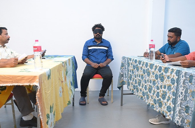 deepu sitting blindfolded between witnesses.jpg