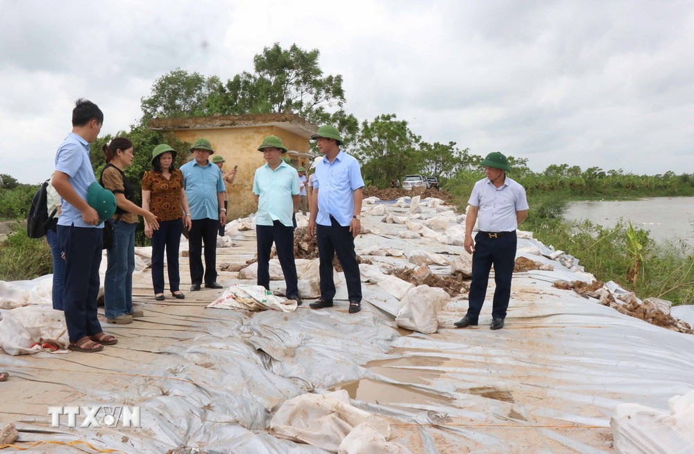 Phó Chủ tịch Ủy ban Nhân dân tỉnh Bắc Ninh Lê Xuân Lợi (thứ 2, bên phải) kiểm tra sự cố đê điều tại bờ Ngũ Huyện Khê, xã Phú Lâm, huyện Tiên Du, Bắc Ninh. (Ảnh: Thái Hùng/TTXVN)