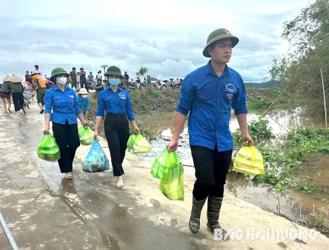 Thanh niên Kim Thành chuẩn bị cơm gửi tặng bà con di dời khỏi vùng có nguy cơ ngập lụt ở thôn Bồ Nông (xã Tuấn Việt, Kim Thành) và các lực lượng làm nhiệm vụ