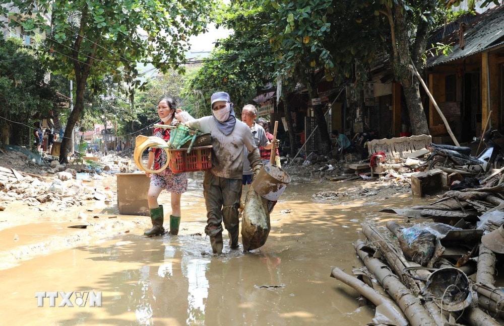 Người dân vẫn phải lội bùn khi di chuyển trên 2 tuyến phố Thanh Niên và Trần Hưng Đạo, Yên Bái, chiều 14/9. (Ảnh: Tuấn Anh/TTXVN)